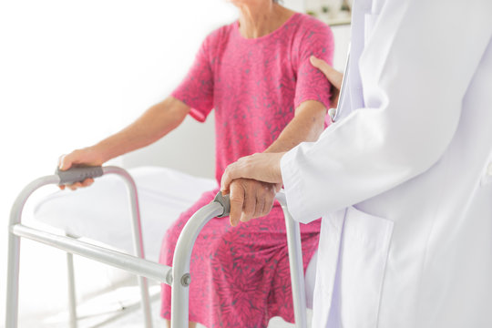 Walk Training And Rehabilitation Process, Old Stroke Patient Use Walker With Doctor In Hospital