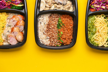 Containers with healthy food on color background