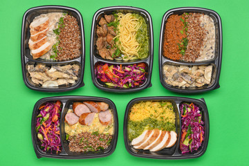 Containers with healthy food on color background