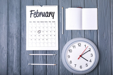 Notebook, calendar and clock on wooden background. Time management concept