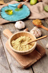 Bowl with dry mustard on wooden background