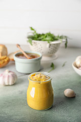 Fototapeta na wymiar Jar of tasty honey mustard sauce on color background