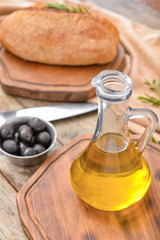 Fototapeta na wymiar Bottle of tasty olive oil on wooden table