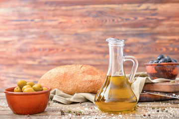 Fototapeta na wymiar Bottle of tasty olive oil on wooden table