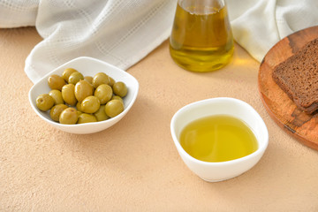 Bowl of tasty olive oil on table