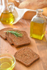 Tasty olive oil with bread on table