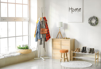 Stylish interior of modern hall with winter clothes