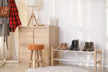 Stylish interior of modern hall with winter clothes