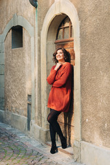 Fototapeta na wymiar Outdoor portrait of pretty woman wearing brown knitted pullover dress