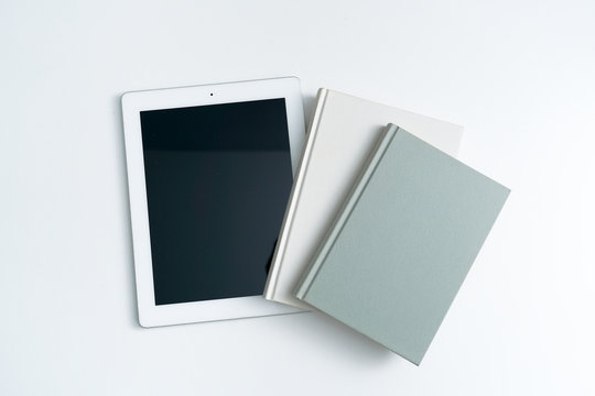 ebook and books on white desktop.Books and tablet on white background.