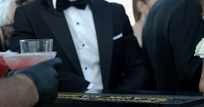 the barmen is preparing cocktail ang giving to people