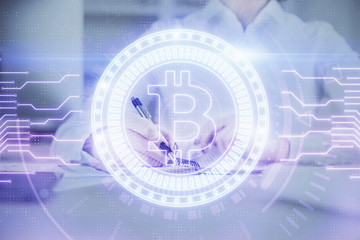 Cryptocurrency hologram, bitcoin, ico theme over hands taking notes background. Concept of...