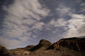 Cloudy Night under the Moonlight with stars peaking through in the space between. A great expance...