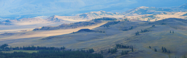 Fototapeta premium Panoramic view, light on the hills in a mountain valley