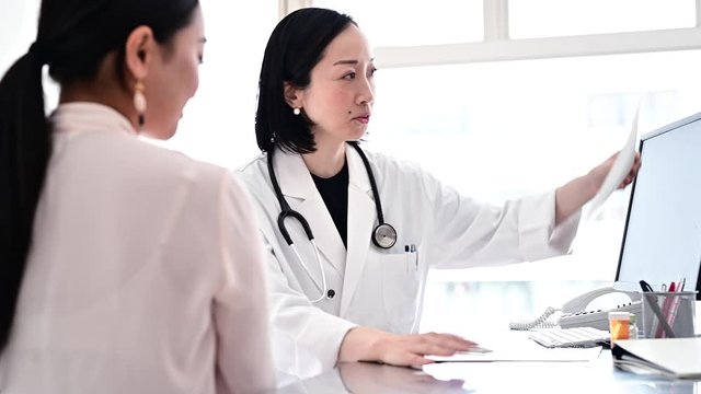 患者にレントゲンの説明をする医師