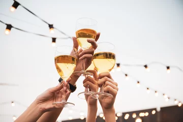  Group of people in party and celebrating together with white wine. Happy Asian people enjoy partying in festival and celebrate with white wine on the roof top bar and restaurant of 5 stars hotel. © DG PhotoStock