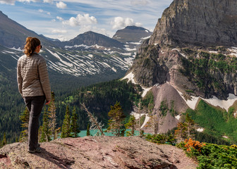 Woman in Gray Coat Stands Above Grinnell Lake