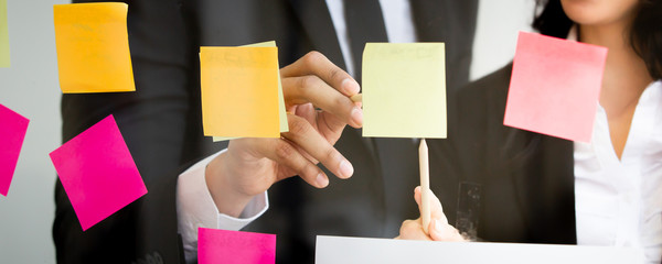 Diversity ethnicity professional businesspeople having a brainstorm and discussing together in their workplace, collaboration and teamwork in expertise businessperson. Businesspeople use sticky note.