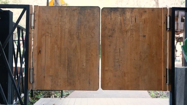 Double small old wooden door with hinges, which must be pushed in and out to the cafe outdoor.