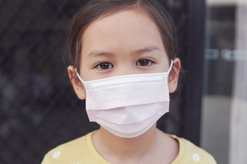 Asian little girl wearing medical face mask, self-quarantine,  coronavirus, covid-19 delta virus...