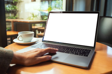 Mockup image of a woman using and touching on laptop touchpad with blank white desktop screen with coffee cup on the table