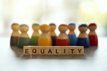EQUALITY word on wooden blocks with diverse people in the background