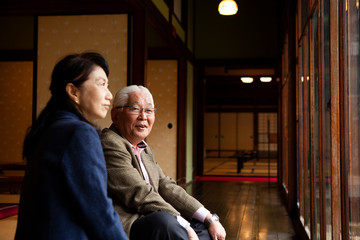 日本庭園を眺める高齢の夫婦