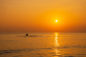 Black silhouette, beautiful sunset with a fishing boat, Mae Ramphueng Beach, Rayong Province, Thailand