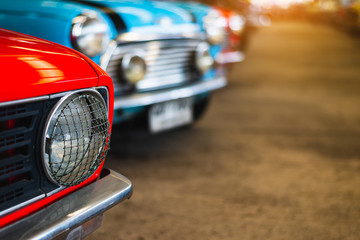 Close-up of headlights of red vintage car in a row.