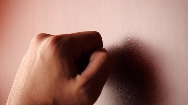 Male Knocks on a wooden door with his hand. Debt and tax concept