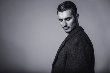 Black and white portrait of young and handsome model in a classic black jacket. Studio shot.