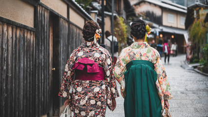 Fototapeta premium Young women wearing traditional Japanese Kimono with colorful maple trees in autumn is famous in autumn color leaves and cherry blossom in spring, Kyoto, Japan.