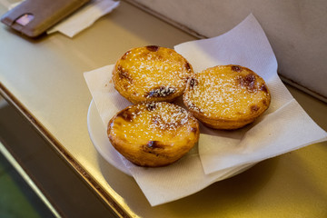 Portuguese egg tarts pasteis de nata on counter covered with powdered sugar
