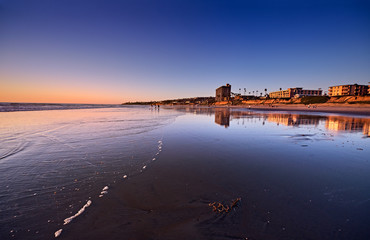 Fototapeta premium Ciepło zachodzącego słońca rozjaśnia wybrzeże w Pacific Beach w pogodny zimowy wieczór