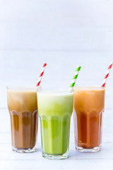 Ice milk coffee, green tea, Iced Thai milk tea drink in tall glasses isolated on white wooden table background, drinks so delicious and snack, Selective focus and copy space.