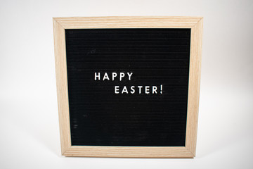 An Isolated Black Happy Easter Sign With White Letters on Black With a Birch Frame