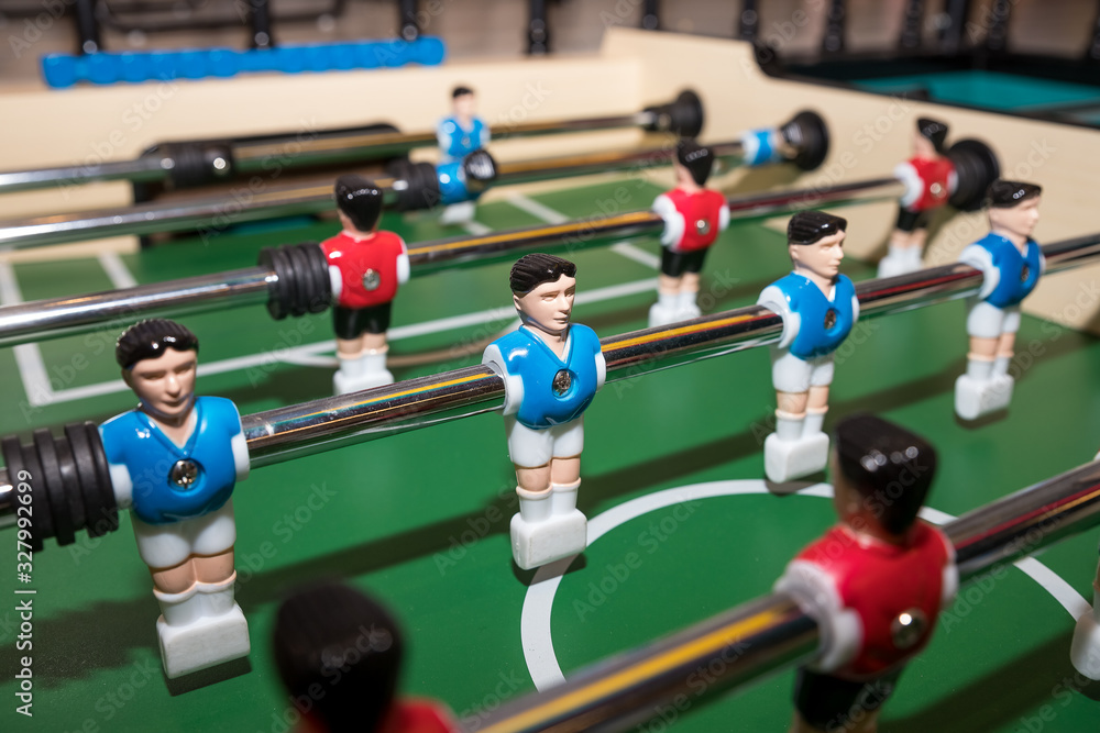 Wall mural vintage foosball, blue and red players team in table soccer or football kicker game, selective focus