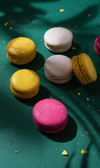 a few  colorful  macaron with deep shadow on a green  background