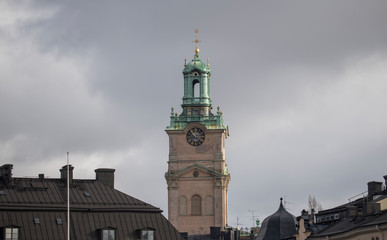The tower of the church Storkyrkan  or Sankt Nicolai kyrka and roofs in the old town Gamla Stan in Stockholm a winter day