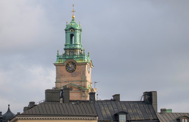 Fototapeta na wymiar The tower of the church Storkyrkan or Sankt Nicolai kyrka and roofs in the old town Gamla Stan in Stockholm a winter day