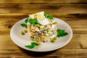 Traditional Russian festive salad Olivier on wooden table