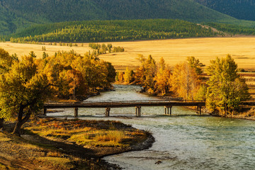 Wooden bridge over the Chuya river in the Kurai steppe, dawn. Altai Republic, Russia