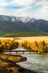 Wooden bridge over the Chuya river in the Kurai steppe, dawn. Altai Republic, Russia
