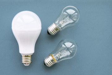 Energy-saving lamp with incandescent lamps on a gray background. The concept of saving energy.