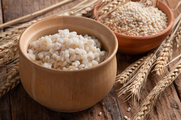 Cooked peeled barley grains in wooden bowl