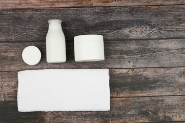 Body and skin care products in white packaging on a wood background. Personal hygiene products. View from above. with space for text