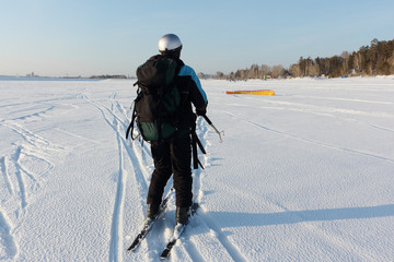 Fototapeta na wymiar Man man lifting a kite from the snowy surface of a reservoir, Novosibirsk, Russia