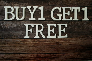 Buy 1 Get 1 Free  with space copy on wooden background