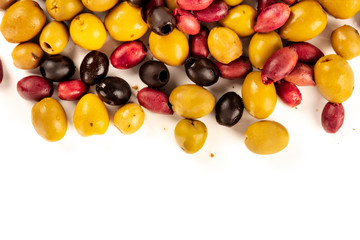 Many different olives, green, black and red, shot from the above on a white background with a place for text