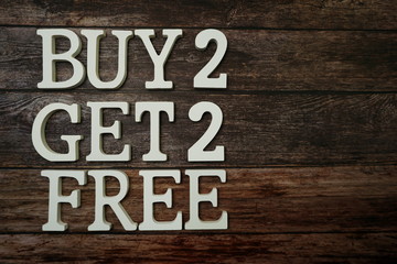 Buy 2 Get 2 Free with space copy on wooden background